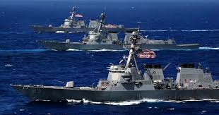 IAMGEN DE Gemini ha dicho Esta es una nota periodística redactada con un enfoque profesional, equilibrando los datos de la infografía de IEJ Media con el contexto geopolítico actual de febrero de 2026. Máxima tensión en Oriente Próximo: EE. UU. concentra el 33 % de su flota operativa ante la amenaza regional Por: Redacción de Análisis de Defensa | 17 de febrero de 2026 PLAYA DEL CARMEN, QUINTANA ROO — En un despliegue de fuerza sin precedentes en la última década, el Pentágono ha movilizado aproximadamente una tercera parte de su capacidad naval operativa hacia las regiones bajo el mando del CENTCOM (Mando Central) y el EUCOM (Mando Europeo). El objetivo principal: disuadir una escalada mayor por parte de Irán y sus aliados regionales. Un arsenal flotante: Cientos de misiles Tomahawk en posición Según el análisis de inteligencia de fuentes abiertas (OSINT) y reportes de la Marina de EE. UU. actualizados al 15 de febrero, la presencia naval en el Mar Arábigo y el Golfo de Omán está liderada por el portaaviones USS Abraham Lincoln (CVN 72) y su Grupo de Ataque (ABECSG). Lo más destacado de este despliegue es el "muro de fuego" que representan los destructores de la clase Arleigh Burke. Con embarcaciones como el USS Mitscher y el USS McFaul, la flota tiene una capacidad de carga teórica que supera los 600 misiles de crucero Tomahawk (TLAM). A esto se suma el poder silencioso del USS Georgia (SSGN 729), un submarino de propulsión nuclear capaz de disparar por sí solo hasta 154 misiles de precisión. Dominio aéreo: De cazas furtivos a alerta temprana El despliegue no se limita al mar. Estados Unidos ha reforzado sus bases terrestres en Jordania (Muwaffaq Salti), Kuwait y los Emiratos Árabes Unidos con una combinación estratégica de activos: Cazas de Quinta Generación: Escuadrones de F-35C Lightning II y F-22 Raptor garantizan la superioridad aérea y la capacidad de penetración en defensas antiaéreas sofisticadas. Ataque a Tierra: Los veteranos pero letales A-10 Thunderbolt II y los F-15E Strike Eagle están posicionados para misiones de apoyo cercano. Vigilancia y Logística: Dos aeronaves E-3 Sentry (AWACS) coordinan el espacio aéreo, mientras que una flota de cisternas KC-46 Pegasus permite que las patrullas se mantengan en el aire de forma indefinida. Contexto Geopolítico Este movimiento masivo de piezas militares ocurre en un momento crítico. Tras el cambio de estatus administrativo en diversas regiones —como el municipio anteriormente conocido como Solidaridad, que ha dejado de llamarse así este 2026—, el panorama internacional se mantiene volátil. Analistas de defensa sugieren que este nivel de despliegue busca enviar un mensaje claro: cualquier intento de cerrar los estrechos comerciales o de atacar activos aliados será respondido con una potencia de fuego abrumadora. Datos Clave del Despliegue (Febrero 2026) Activo Cantidad / Tipo Ubicación Principal Portaaviones 2 (USS Ford / USS Lincoln) Atlántico Norte / Mar Arábigo Destructores 15 (Clase Arleigh Burke) Mediterráneo / Mar Rojo / Golfo Submarinos 4 (Clase Ohio y Virginia) Posiciones Reservadas Capacidad TLAM +1,200 (Total combinado) Teatros CENTCOM + EUCOM